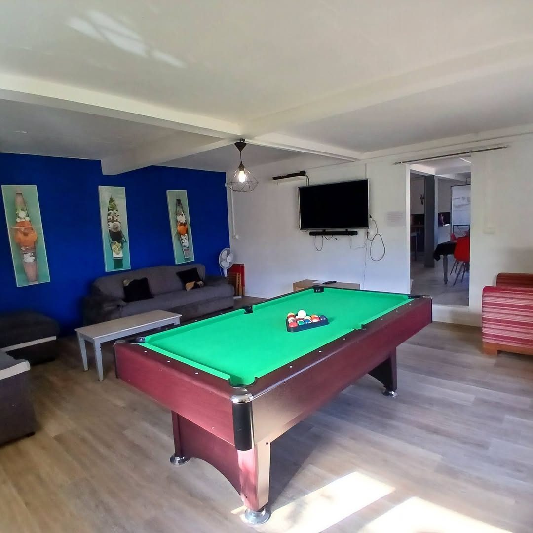 Salon avec billard, canapé et télévision